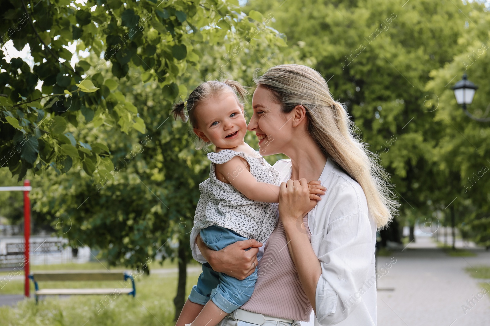 Photo of Happy mother with her daughter spending time together in park. Space for text