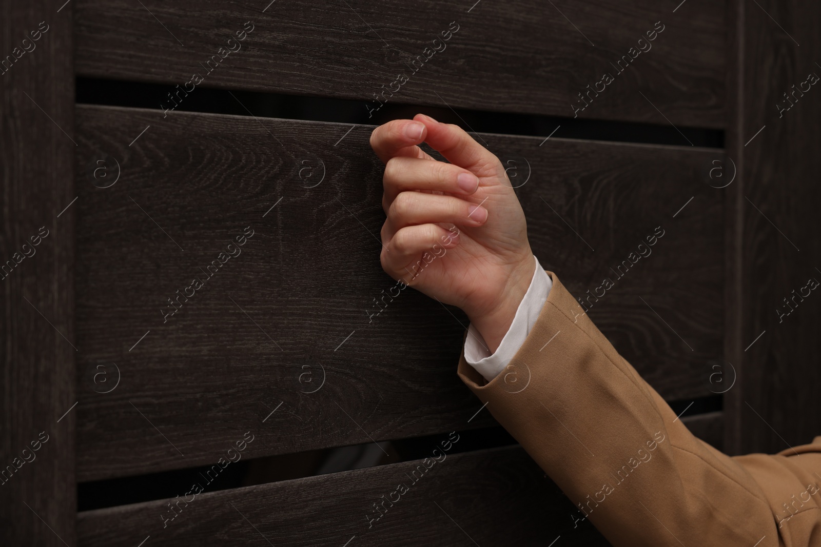 Photo of Collector knocking on door indoors, closeup view