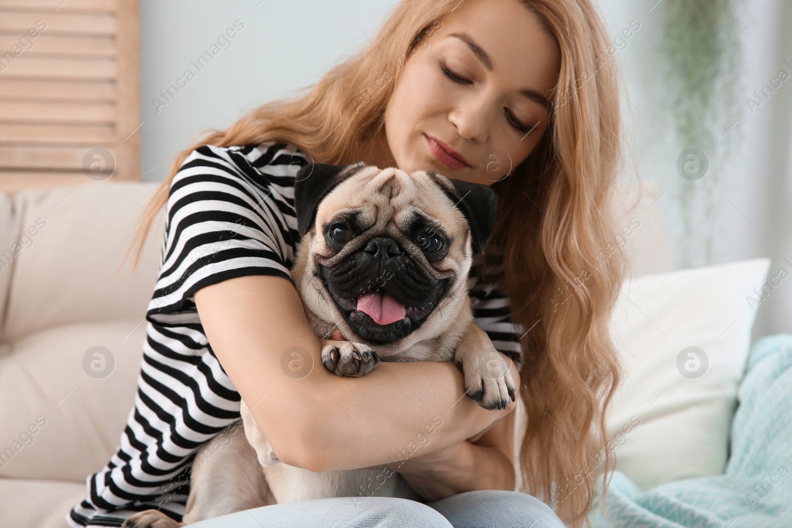 Photo of Woman with cute pug dog at home. Animal adoption