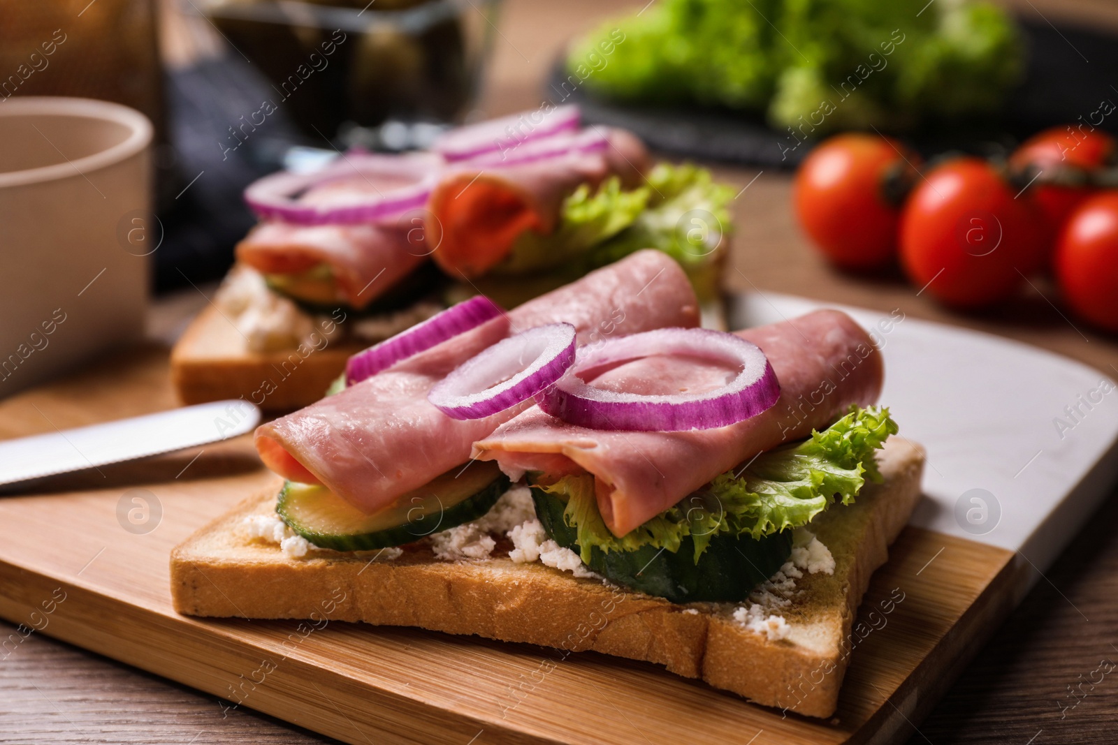 Photo of Delicious sandwiches with ham on wooden table, closeup