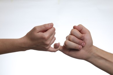 Photo of Man and woman holding little fingers together on white background, closeup