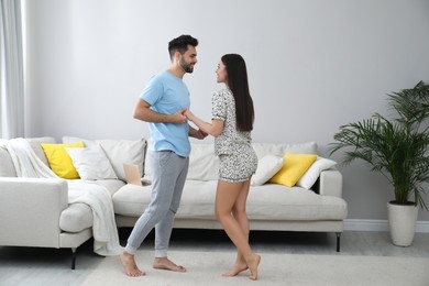 Photo of Happy couple in pajamas dancing at home