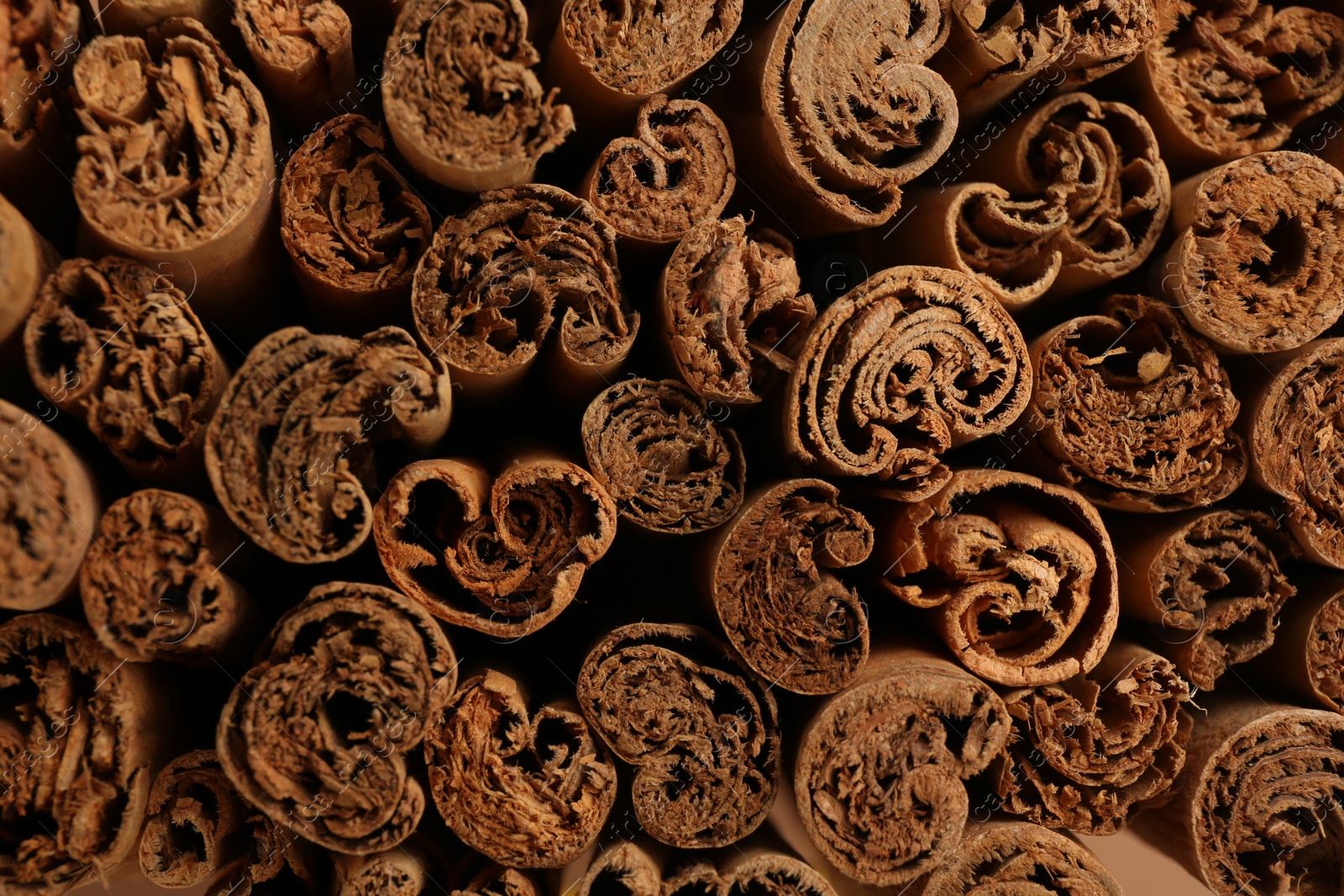 Photo of Aromatic cinnamon sticks as background, top view