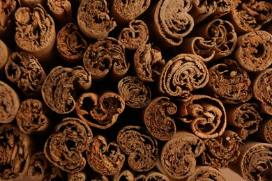 Aromatic cinnamon sticks as background, top view