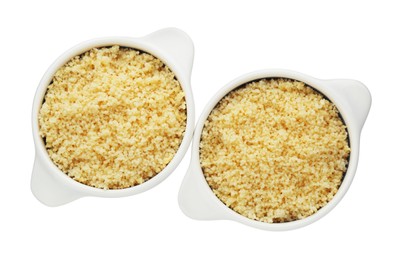 Bowls with tasty couscous on white background, top view