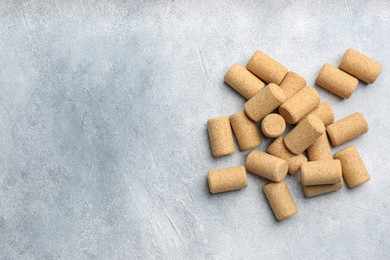 Photo of Wine bottle corks on light grey table, flat lay. Space for text