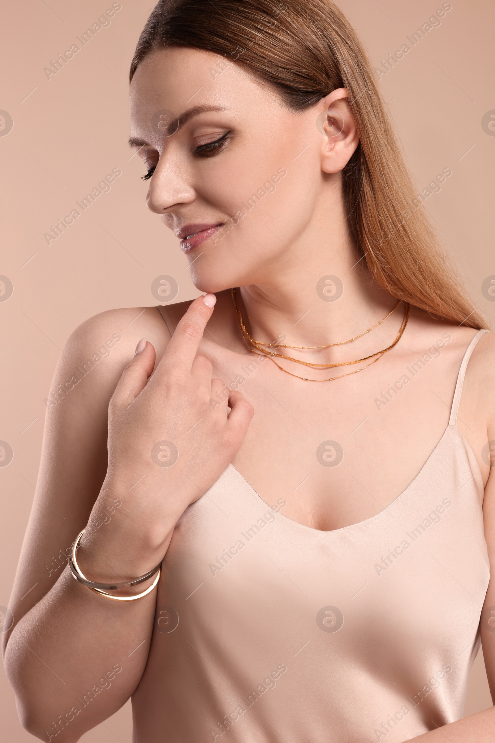 Photo of Beautiful woman with elegant jewelry on beige background