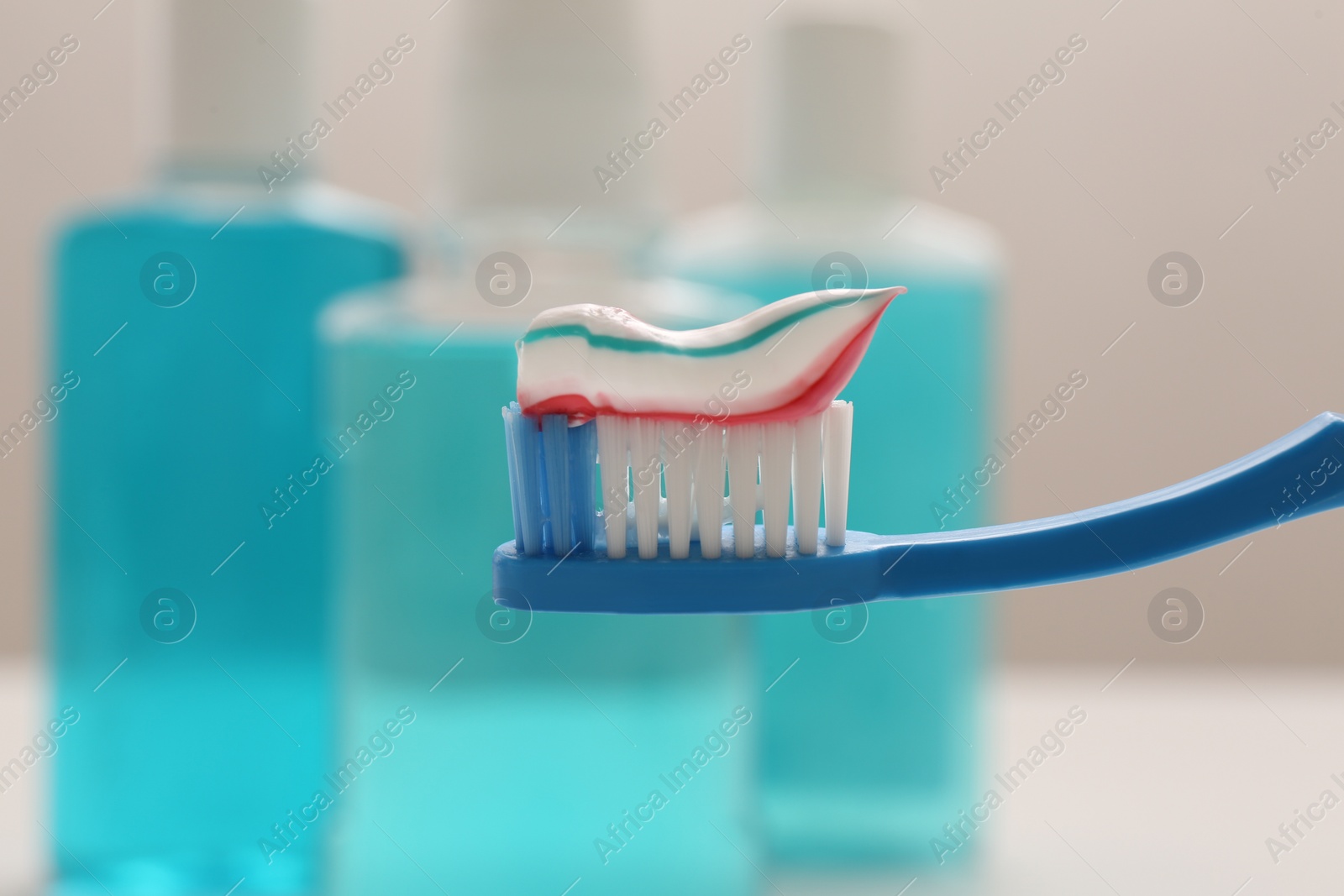 Photo of Brush with toothpaste on blurred background, closeup