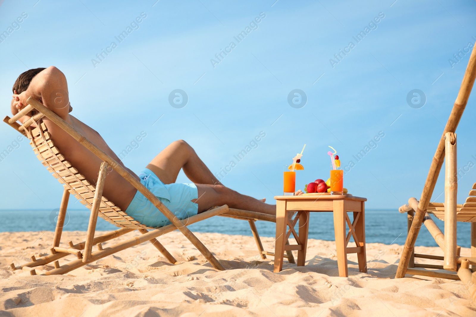 Photo of Happy man resting on sunny beach at resort