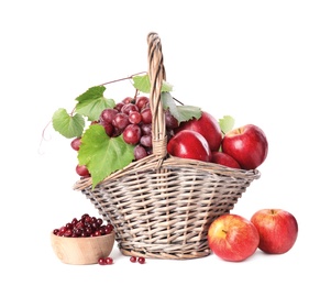 Wicker basket with fresh fruits and berries on white background