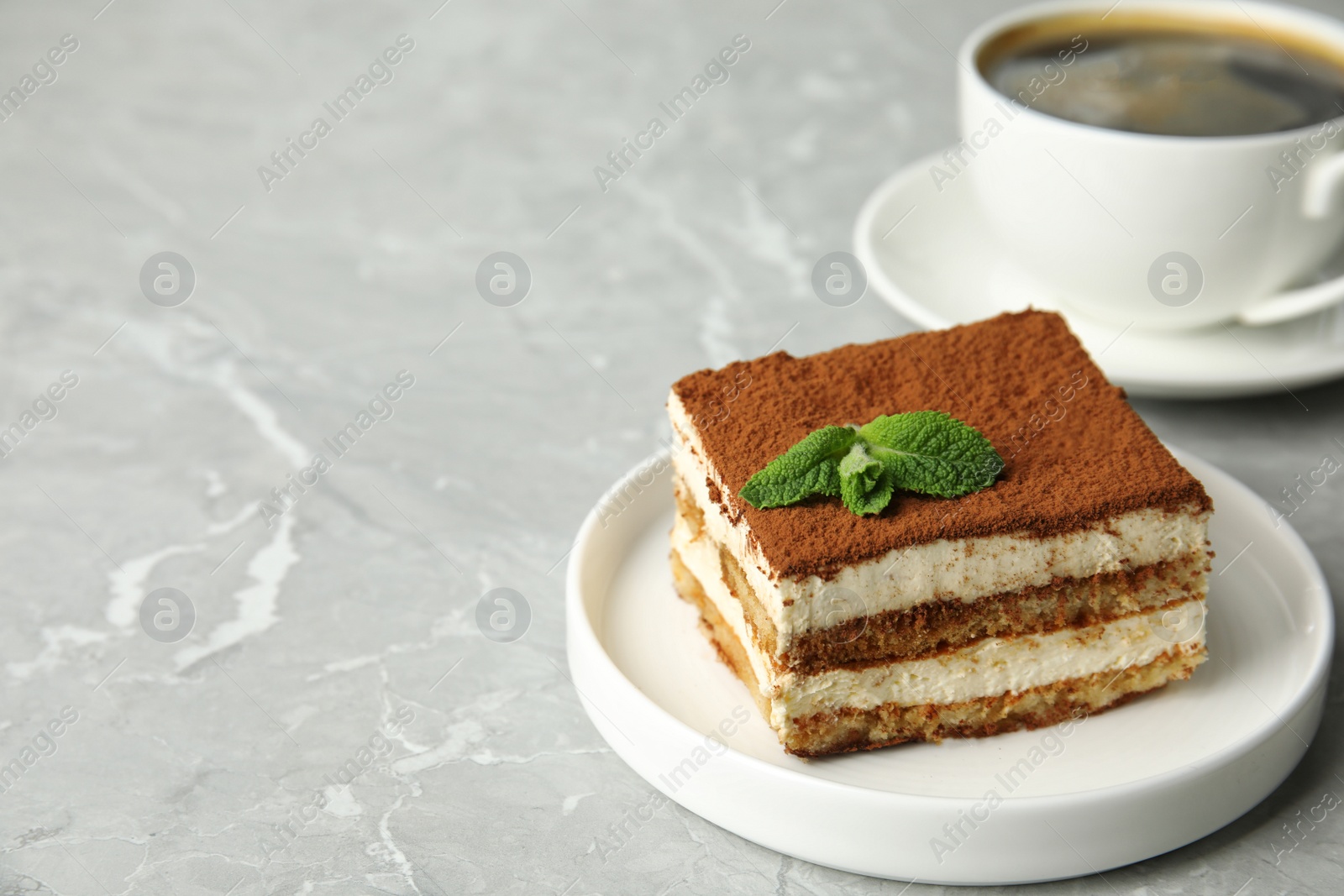 Photo of Tiramisu cake with cup on table, space for text