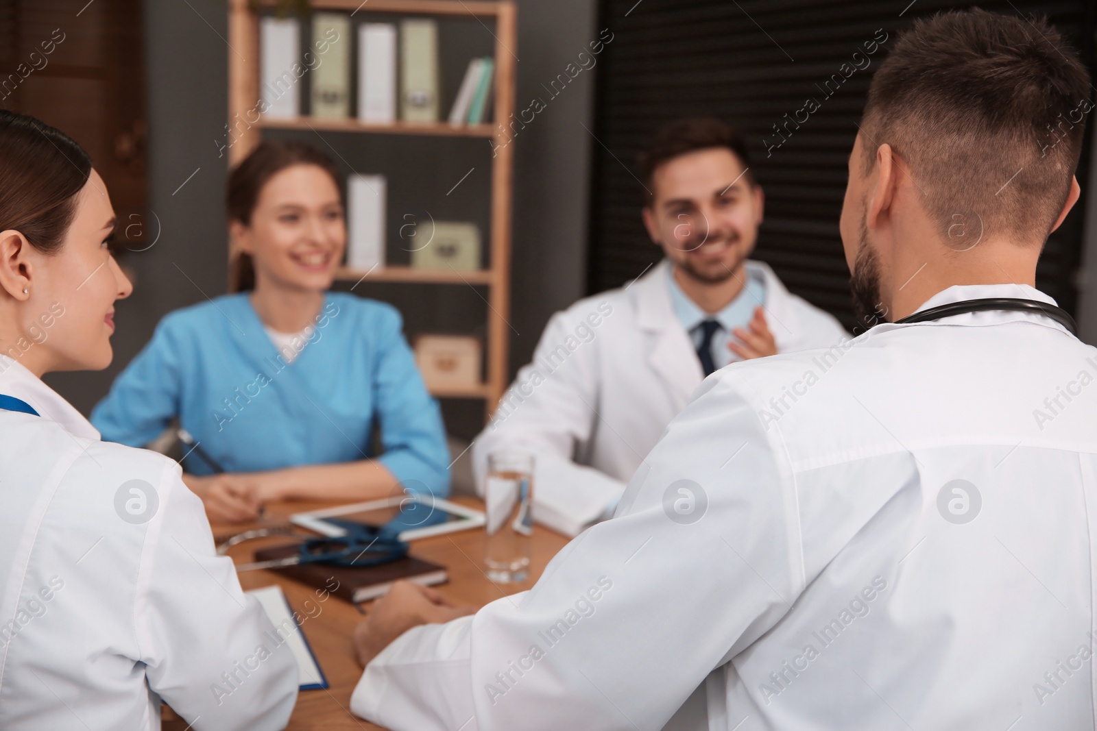 Photo of Team of professional doctors having meeting in office