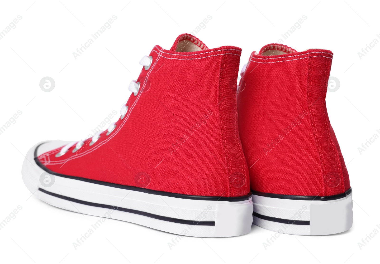 Photo of Pair of new red stylish high top plimsolls on white background