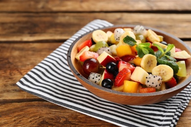 Photo of Delicious exotic fruit salad on wooden table
