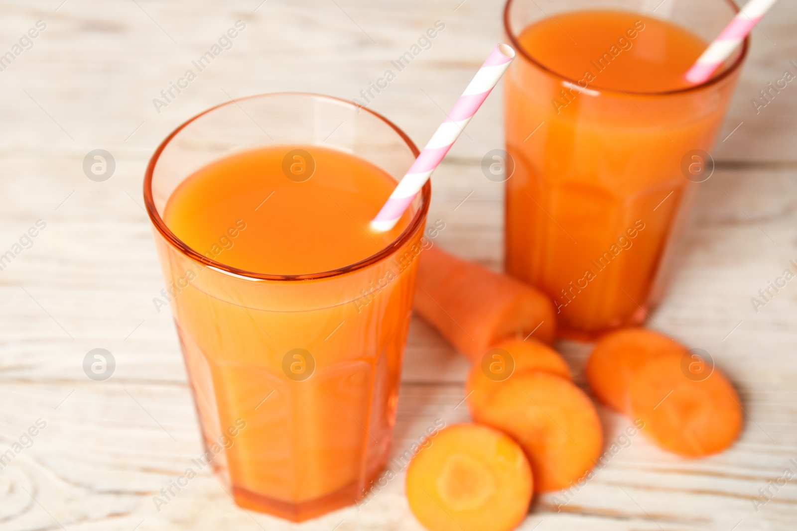 Photo of Freshly made carrot juice on wooden table