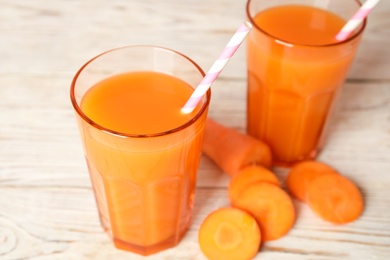 Photo of Freshly made carrot juice on wooden table