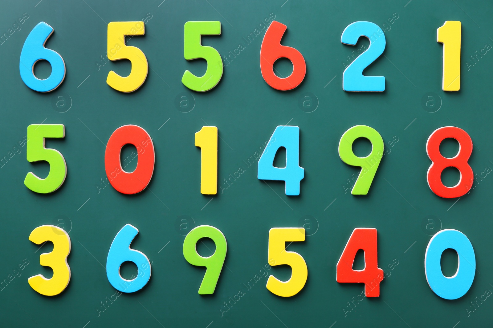 Photo of Colorful numbers on green background, flat lay