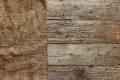 Burlap fabric on wooden table, top view. Space for text