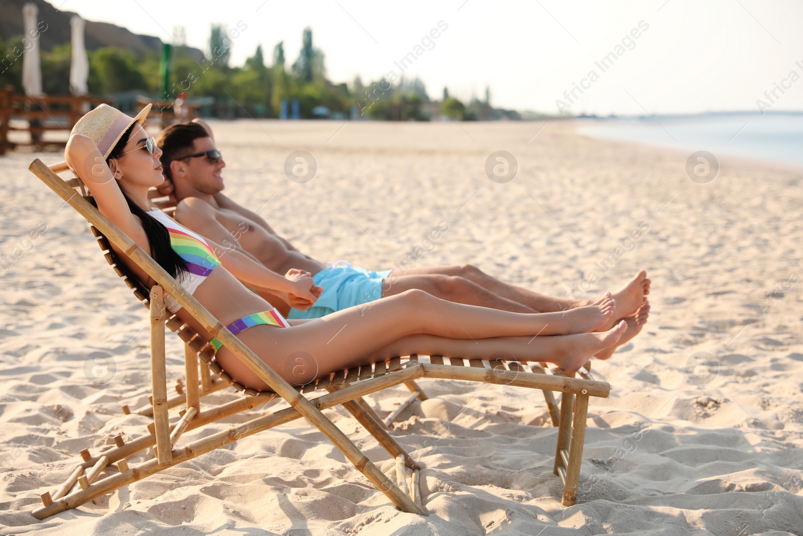 Photo of Couple resting on sunny beach at resort