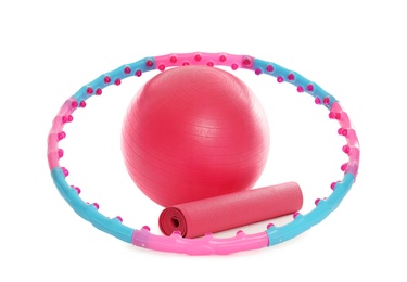 Hula hoop, exercise ball and yoga mat on white background