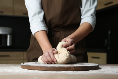 Female baker preparing bread dough at table, closeup