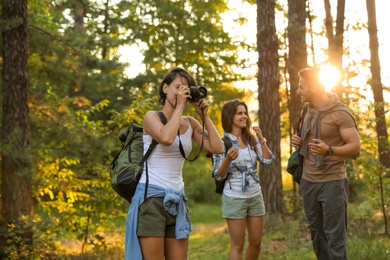 Photo of Young friends in forest on summer day. Camping season