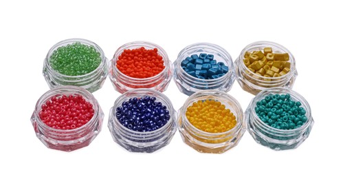 Plastic containers with different beads on white background