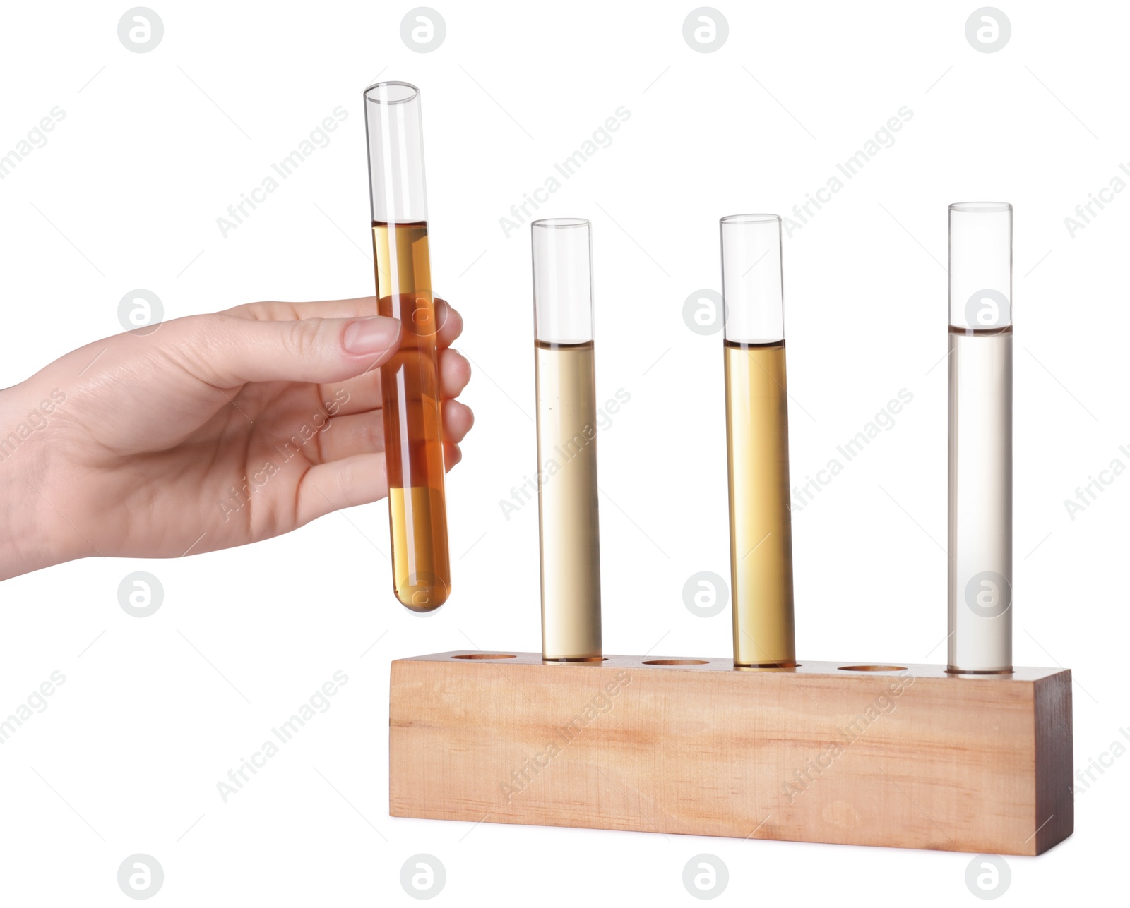 Photo of Woman taking test tube with light brown liquid from stand on white background, closeup