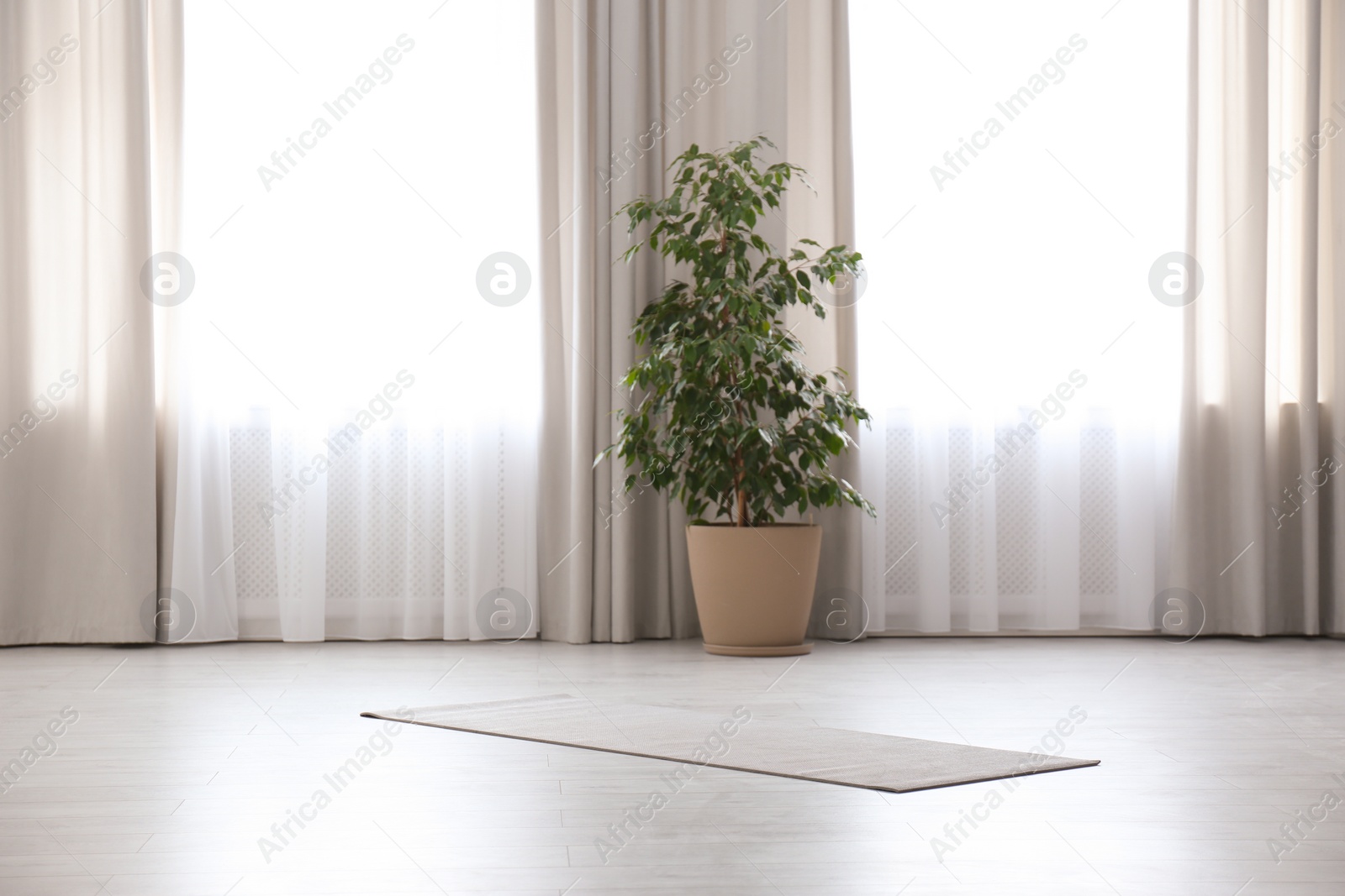 Photo of Grey yoga mat on floor in spacious room