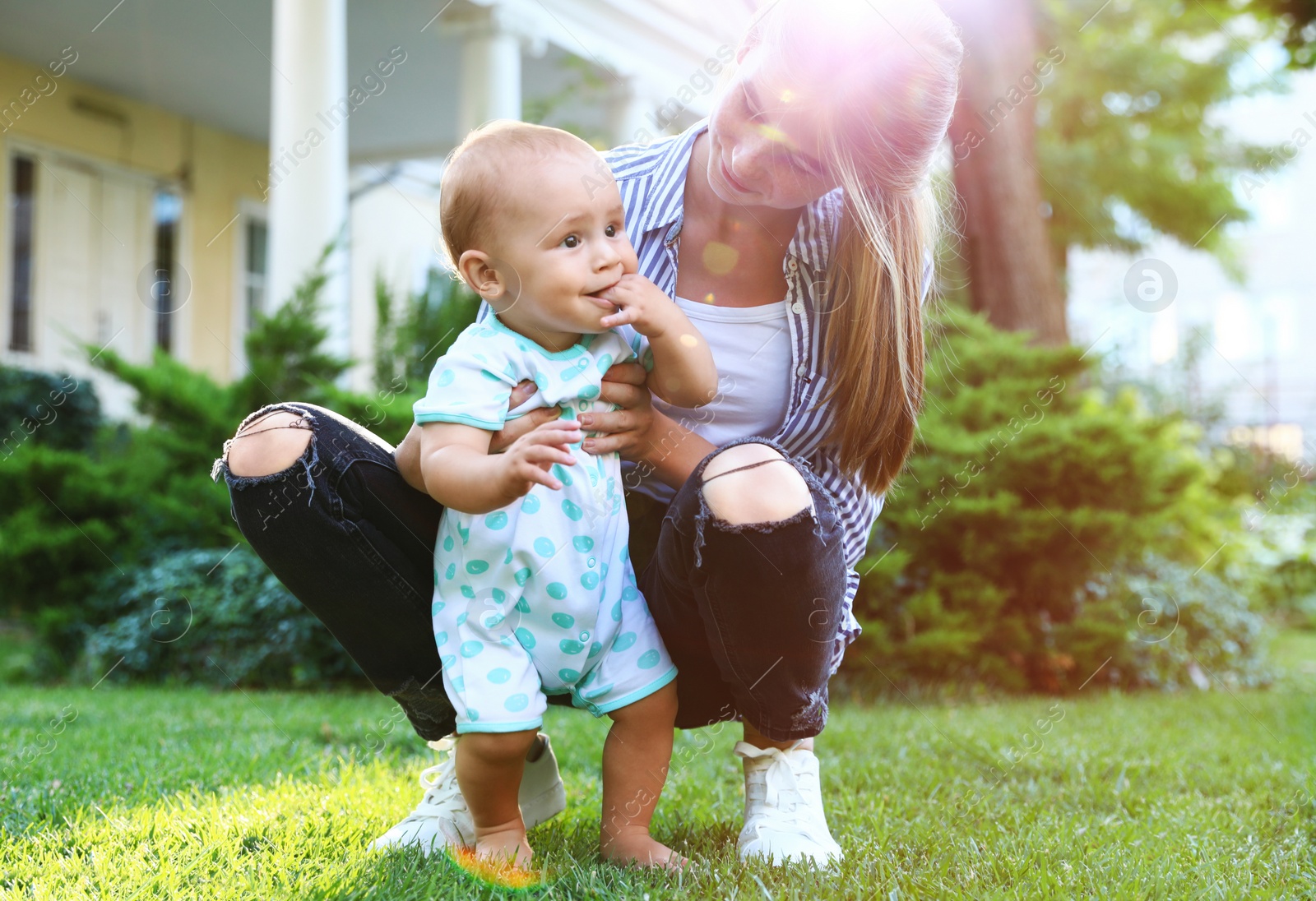 Photo of Teen nanny with cute baby on green grass outdoors