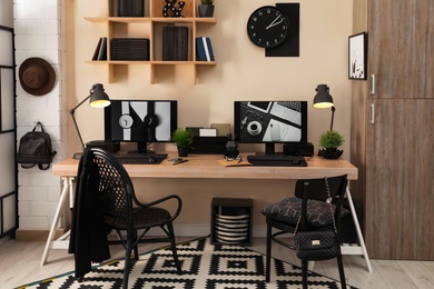 Photo of Stylish workplace interior with computers on table