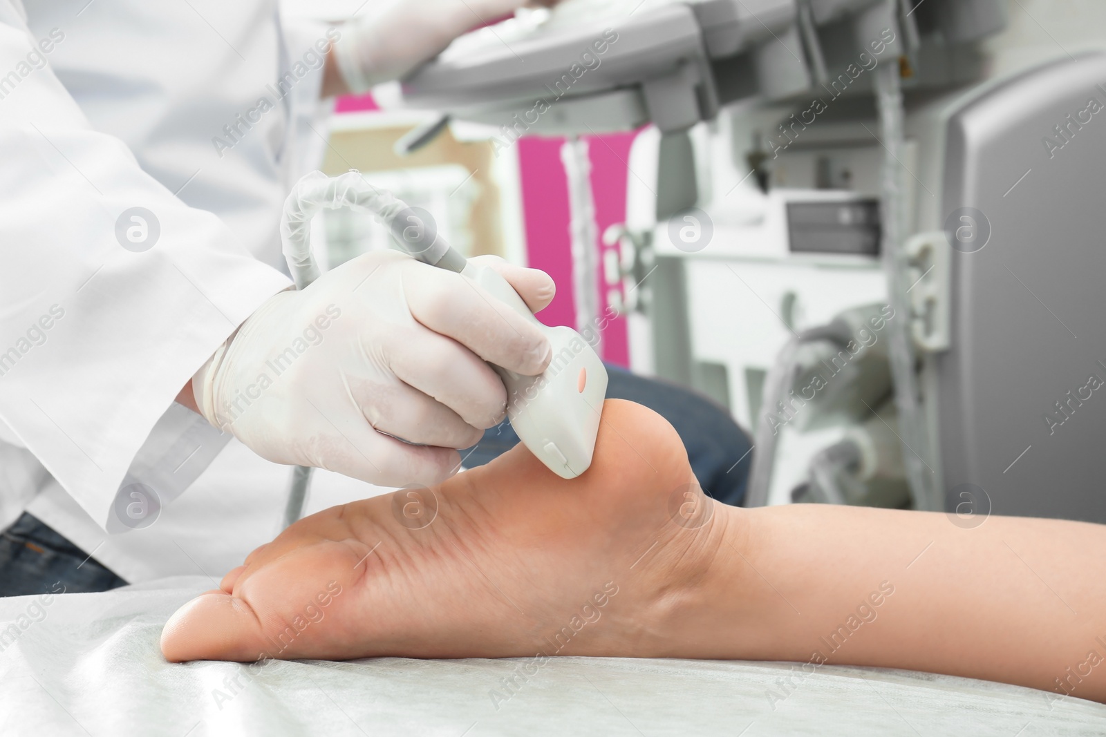 Photo of Doctor conducting ultrasound examination of patient's foot in clinic, closeup