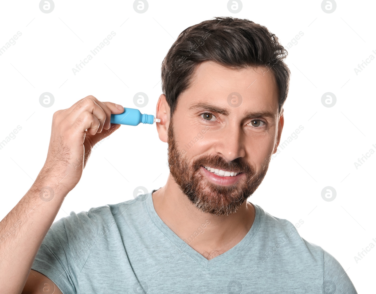 Photo of Man using ear drops on white background