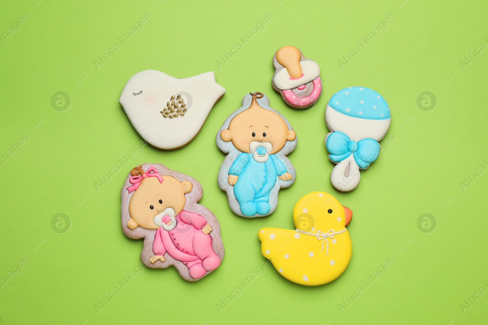 Photo of Set of baby shower cookies on light green background, flat lay