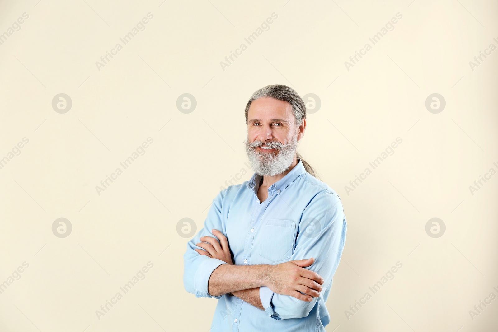 Photo of Portrait of handsome mature man on color background