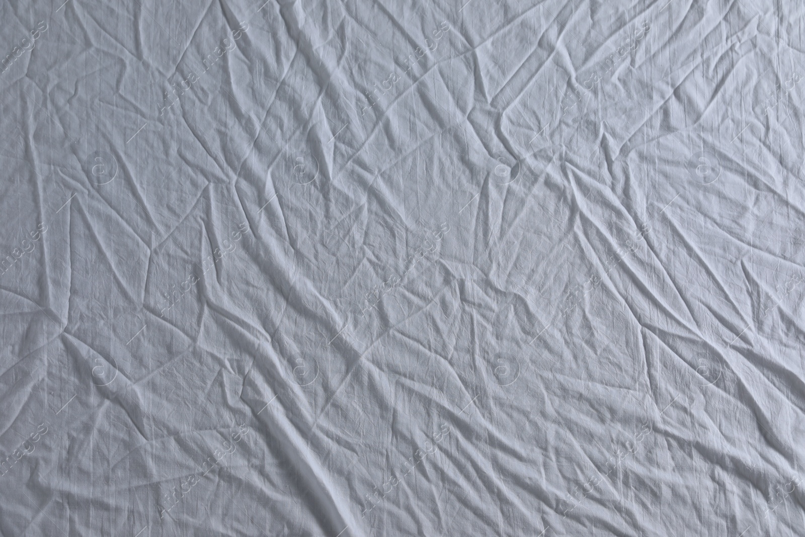 Photo of Crumpled white fabric as background, top view