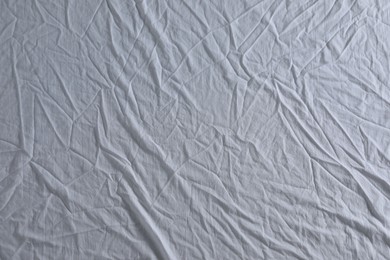 Photo of Crumpled white fabric as background, top view