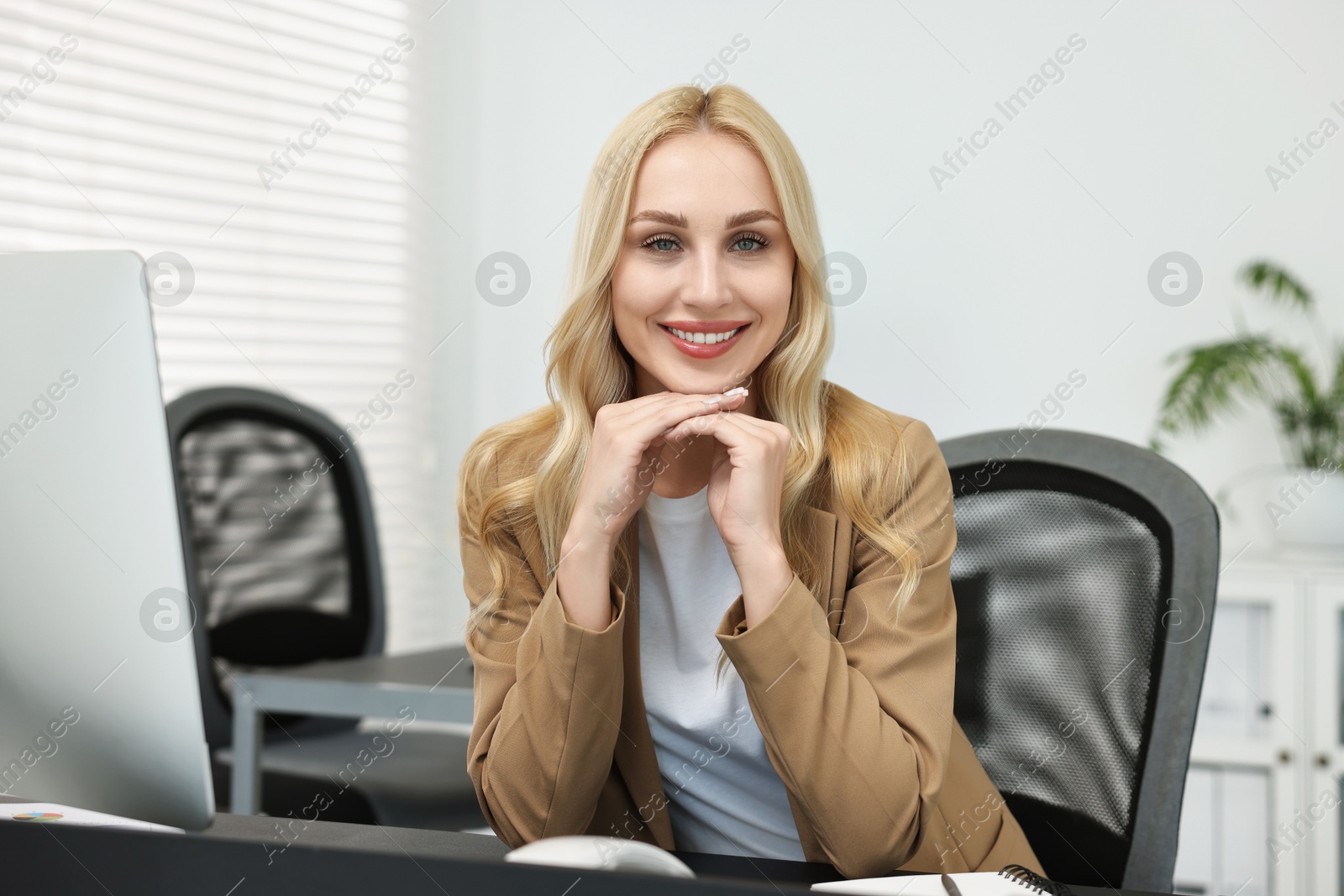 Photo of Portrait of happy secretary at table in office