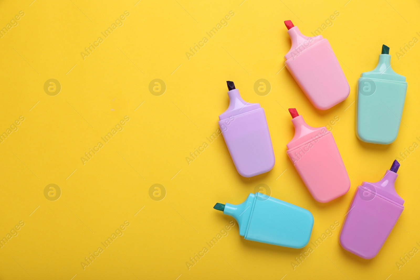 Photo of Many colorful markers on yellow background, flat lay. Space for text