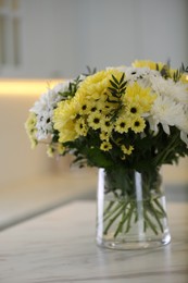 Photo of Vase with beautiful chrysanthemum flowers on table in kitchen. Interior design