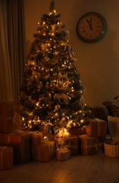 Photo of Stylish Christmas interior of living room with beautiful tree in evening
