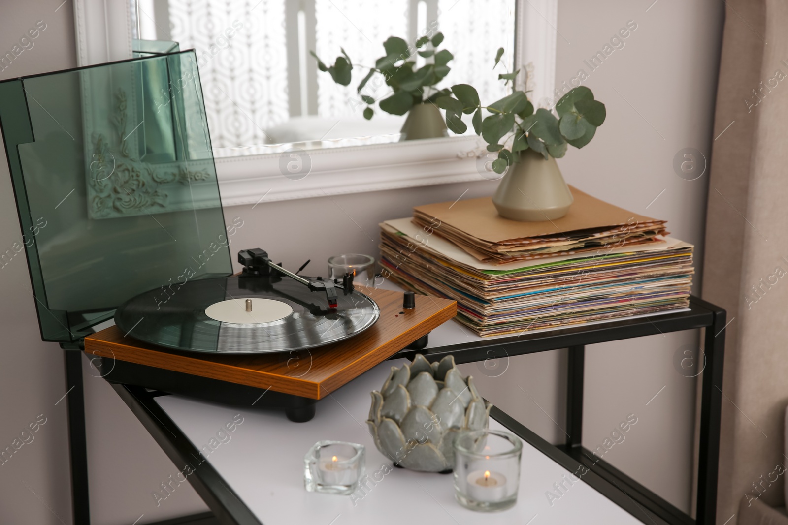 Photo of Stylish turntable with vinyl record on table indoors