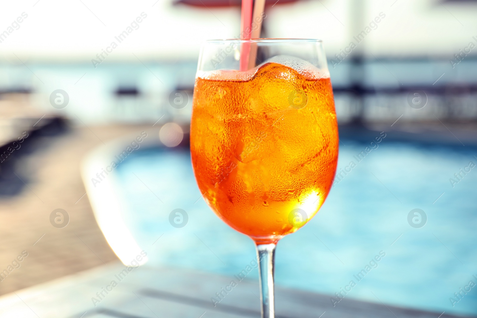 Photo of Glass of fresh summer cocktail at poolside outdoors, closeup