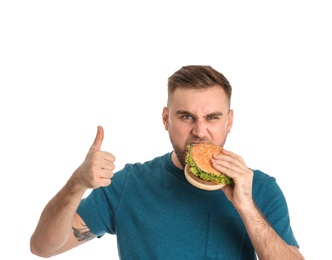 Photo of Young man eating tasty burger on white background