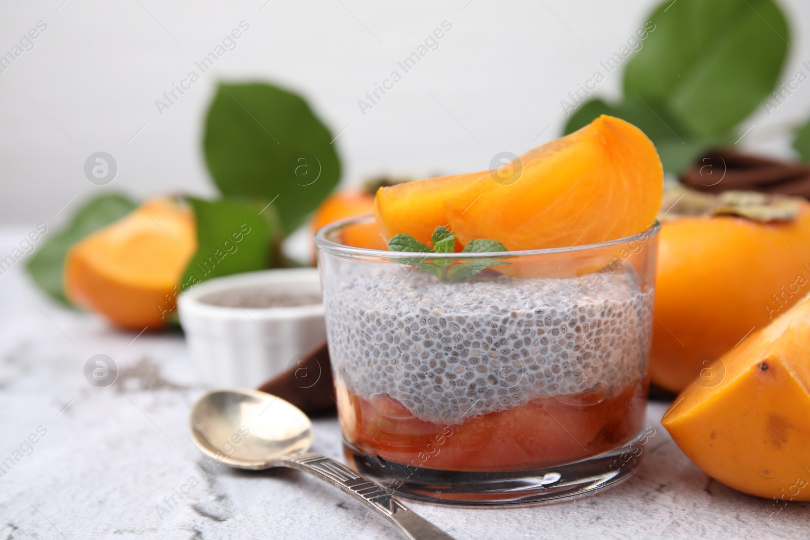 Photo of Delicious dessert with persimmon and chia seeds on table