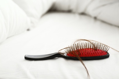 Photo of Cushion brush with fallen hair on white sheet