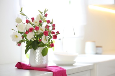 Vase with fresh flowers on table in kitchen. Space for text