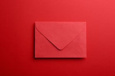 Paper envelope on red background, top view
