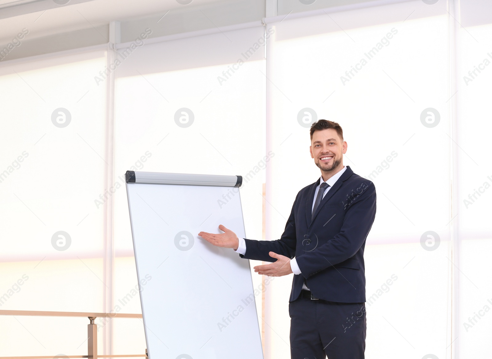 Photo of Young business trainer near flip chart, indoors