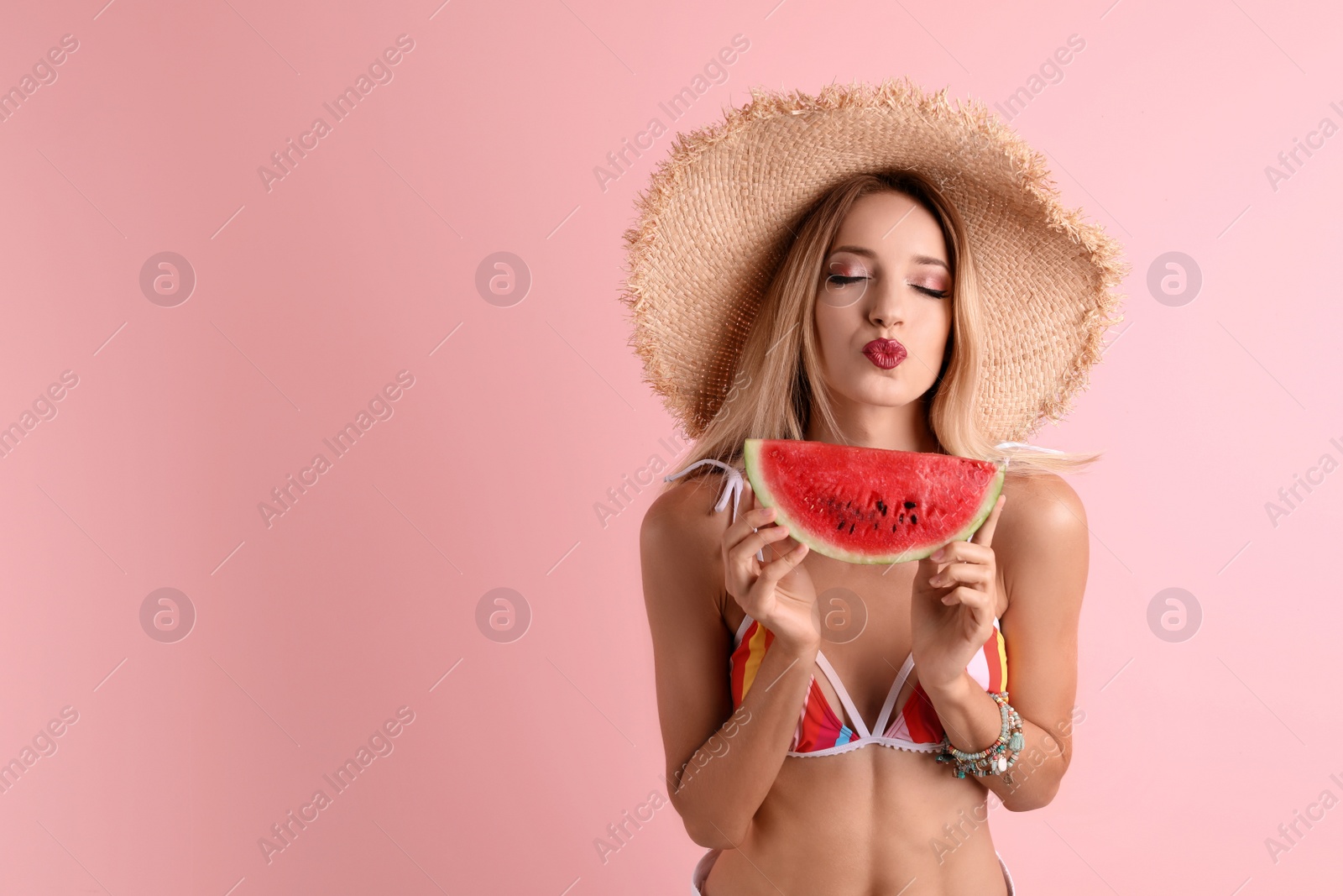 Photo of Pretty young woman with juicy watermelon on color background